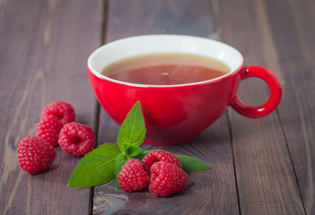 cup of hot black  tea with mint and raspberry