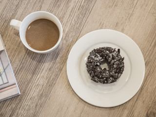 Chocolate Donut and cup of coffee on wooden background