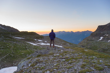 Fototapeta premium One person watching sunrise high up in the Alps