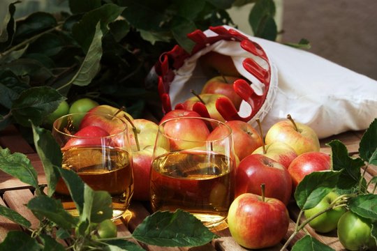 Fresh apple juice and apples on a wooden table