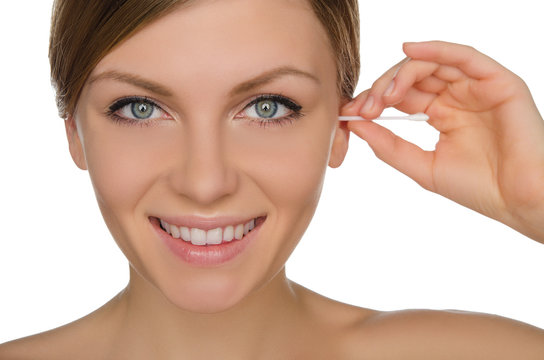 smiling woman cleans ears with cotton sticks