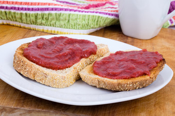 Strawberry and rhubarb jam on toast bread for breakfast on table