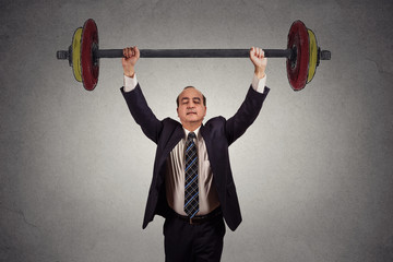 Successful business man effortlessly lifting heavy barbell