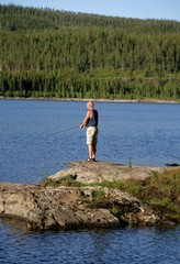 Fototapeta na wymiar Man Fishing by a lake