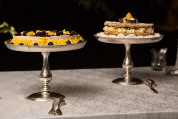 Due torte con creme colorate su vassoi in silver