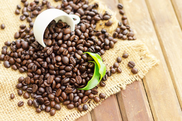 coffee beans with white cup and green leaves