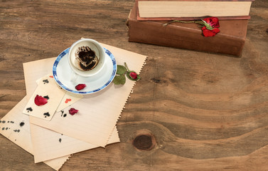    Tazzina  vuota con fondo di caffè in forma di cuore,carte da gioco,petali di rosa secchi su...