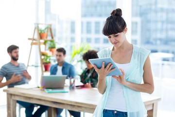 Smiling young businesswoman using tablet