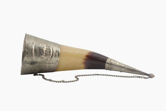 Caucasian wine-drinking horn. Isolated caucasian wine-drinking horn with decorative metal elements lying on a white background.