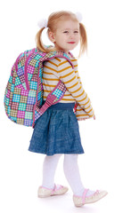 Adorable little girl in pigtails with a big knapsack on his back