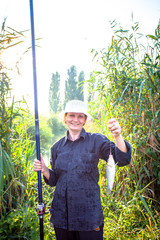 woman aged fished fish at pond in the morning on sunlight