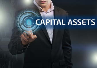 Businessman presses button capital assets on virtual screens. Bu