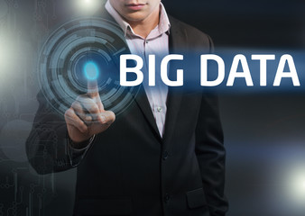 Businessman presses button big data on virtual screens. Business