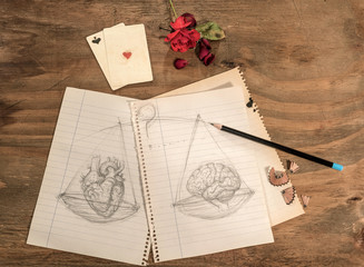   Disegno a matita di cuore e cervello con carte da gioco e rosa rossa su tavolo di legno grezzo. - obrazy, fototapety, plakaty
