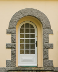 Haustür mit Bogen aus Holz mit Granittüreinfassung

