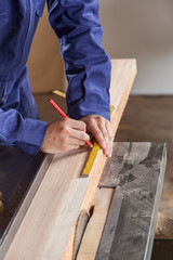 Fototapeta na wymiar Carpenter measuring a piece of wood