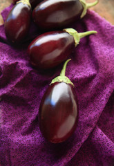 Fresh eggplants on floral print cloth