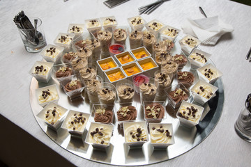 Naklejka premium Assortimento di dolci in crema su vassoio rotondo specchiato