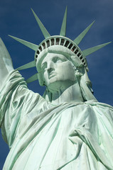 Statue of Liberty close-up vertical profile with crown against blue sky