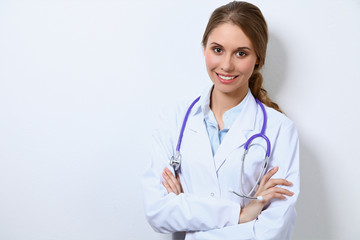 Young female doctor, standing near wall
