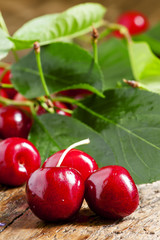Fresh cherries with leaves on the old wooden table, selective fo