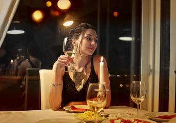 Elegantly-dressed woman sitting at a restaurant