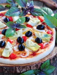 Healthy pizza with artichokes, olives, onions, peppers, basil and olive oil