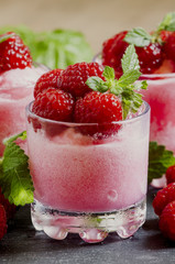 Raspberry granita with berries and mint in glass cups, selective