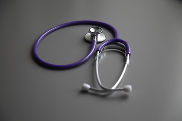 Fototapeta premium Stethoscope on the grey desk, close up