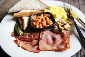 Breakfast with ham , fried egg and bread on wood background low