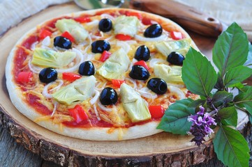 Healthy pizza with artichokes, olives, onions, peppers, basil and olive oil