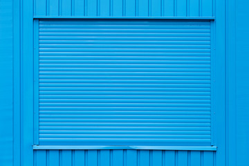 Ein geschlossener blauer Rolladen in einem blauen Wohncontainer