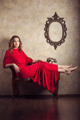 Girl in red dress sitting on a chair