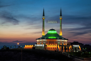 Fototapeta na wymiar Mordern Mosque at Sunset with Ramadan Lights between two minarets