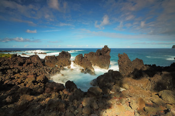 Ocean waves crash on the lava rocky coast at Laupāhoehoe Point