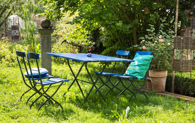 Gemütliche Sitzecke im Garten mit blauen Gartenmöbeln