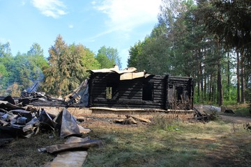 Разрушенный дом в заброшенной деревне на поле летом