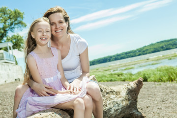 Young mother and her young daughter fun time together outdoors.