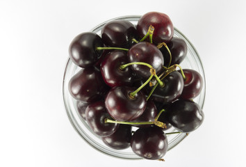 Cherries ( dark red)  in a round glass salad bowl
