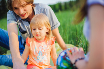 Mother, father and daughter play outside