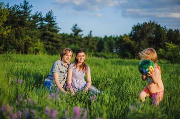 Obraz premium Mother, father and daughter play ball outside