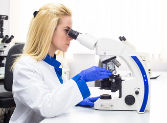Medical worker looking into a microscope 