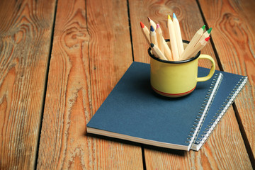 Pencils in a mug on a wooden table