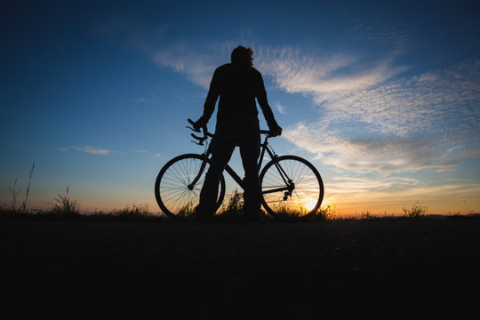 silhouetted cyclist in sunset