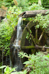 Water from a pipe turning a water wheel