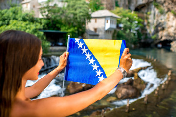 Woman with Bosnian flag in Blagaj village
