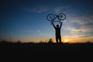 silhouetted cyclist in sunset