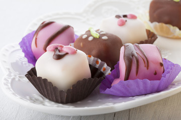 Mignon small sweet cakes on a wooden white board