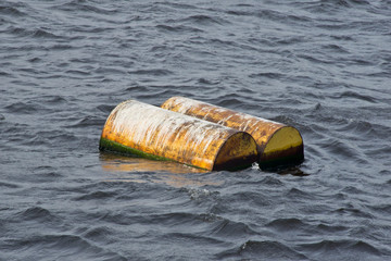 Two yellow barrels drift on water
