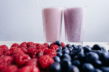 rapsberry and blueberry smoothie with fresh berries on wood tabl
